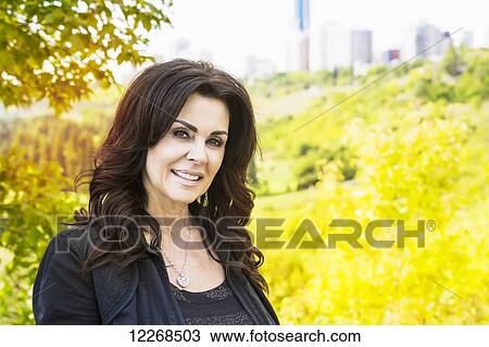 Portrait of a mature businesswoman outdoors in the river valley in autumn; Edmonton, Alberta, Canada View Large Photo Image Stock Image - Portrait of a mature businesswoman outdoors in the river valley in autumn; Edmonton, Alberta, Canada. Fotosearch