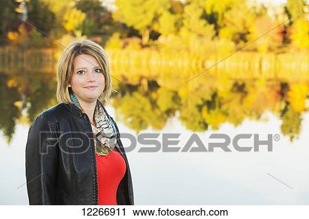 Portrait of a mature woman in a park beside a lake in autumn; Edmonton, Alberta, Canada View Large Photo Image Stock Image - Portrait of a mature woman in a park beside a lake in autumn; Edmonton, Alberta, Canada. Fotosearch