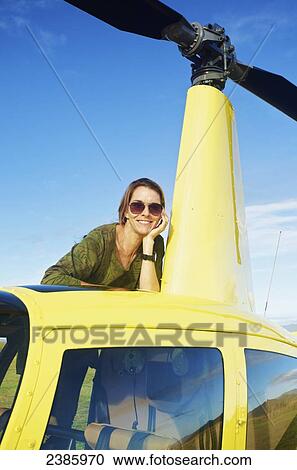 Stock Image - Portrait of a pilot waiting with a helicopter; Kilauea, Hawaii, United States of America. Fotosearch