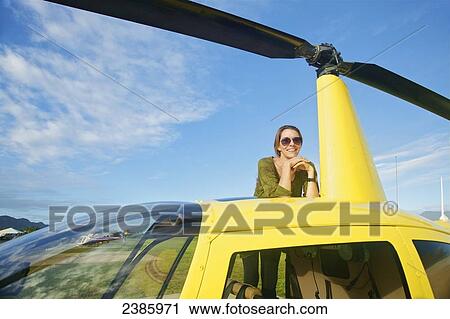 Stock Image - Portrait of a pilot waiting with a helicopter; Kilauea, Hawaii, United States of America. Fotosearch