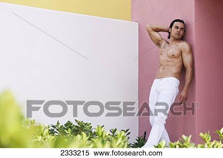 Portrait of a shirtless man leaning against a pink wall; Honolulu, Oahu, Hawaii, United States of America View Large Photo Image Stock Photography - Portrait of a shirtless man leaning against a pink wall; Honolulu, Oahu, Hawaii, United States of America. Fotosearch