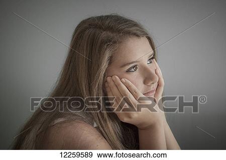 Stock Photo - Portrait of a teenage girl daydreaming; Connecticut, United States of America. Fotosearch