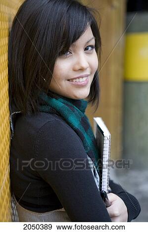 Stock Photo - Portrait Of A Teenage Girl Holding A Notebook. Fotosearch
