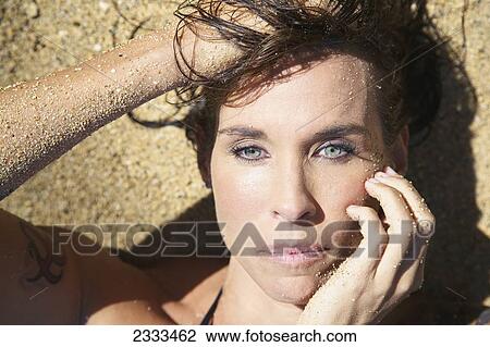 Portrait of a woman laying in the sand; Kauai, Hawaii, United States of America View Large Photo Image Stock Image - Portrait of a woman laying in the sand; Kauai, Hawaii, United States of America. Fotosearch