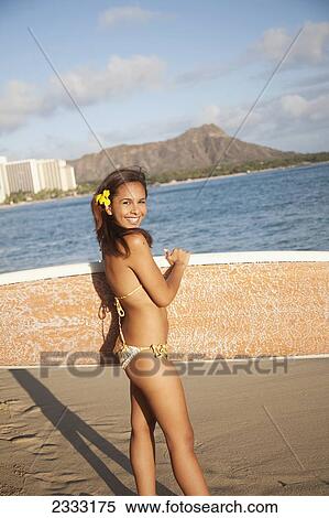 Portrait of a woman on a beach in a bikini holding a surfboard; Waikiki, Oahu, Hawaii, United States of America View Large Photo Image Stock Photography - Portrait of a woman on a beach in a bikini holding a surfboard; Waikiki, Oahu, Hawaii, United States of America. Fotosearch