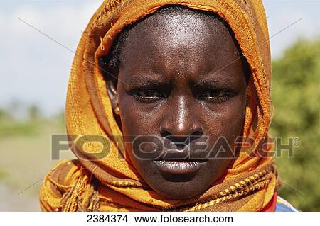 Picture - Portrait of a woman with a yellow headscarf; Omo Valley, Ethiopia. Fotosearch