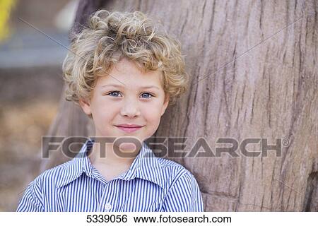 Portrait Of A Young Boy With Blond Curly Hair And Blue Eyes