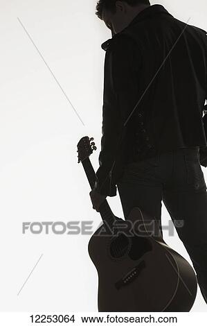 Picture - Portrait of a young man with his guitar; Edmonton, Alberta, Canada. Fotosearch