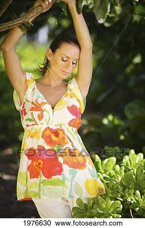 Stock Image - Portrait of a young woman in a floral shirt. Fotosearch