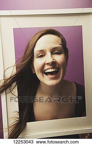 Stock Image - Portrait of a young woman in a picture frame. Fotosearch