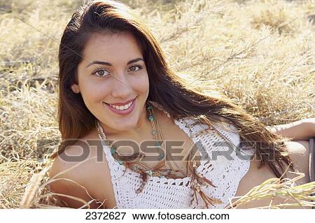 Portrait of a young woman laying in the dry grass; Honolulu, Oahu, Hawaii, United States of America View Large Photo Image Stock Photo - Portrait of a young woman laying in the dry grass; Honolulu, Oahu, Hawaii, United States of America. Fotosearch