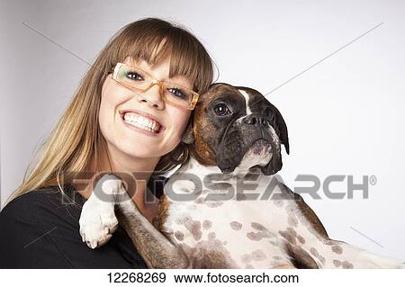 Stock Photo - Portrait of a young woman with her boxer dog; Edmonton, Alberta, Canada. Fotosearch