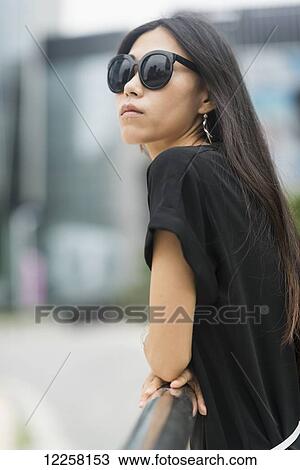 Portrait of a young woman with long brunette hair and sunglasses; Xiamen, China View Large Photo Image Stock Image - Portrait of a young woman with long brunette hair and sunglasses; Xiamen, China. Fotosearch