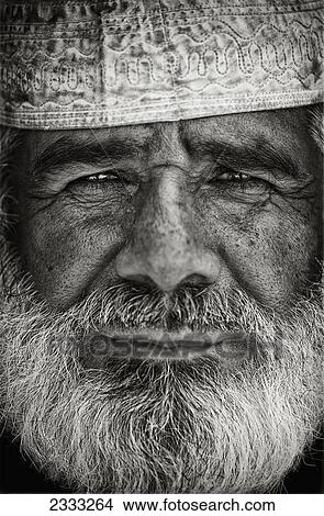 Picture - Portrait Of Bearded Man In Traditional Cap; Al Ain, Abu Dhabi, United Arab Emirates. Fotosearch