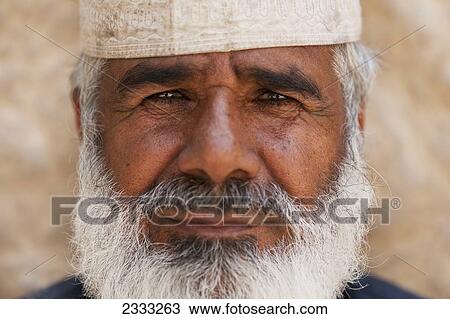 Stock Image - Portrait Of Bearded Man In Traditional Cap; Al Ain, Abu Dhabi, United Arab Emirates. Fotosearch