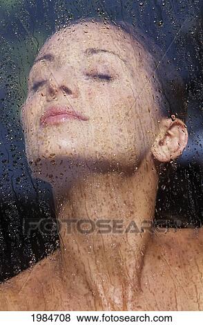 Stock Photo - Portrait Of Beautiful Woman Behind Wet Glass.. Fotosearch
