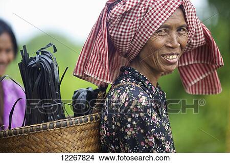 Picture - Portrait of Bunong woman with basket on her back; Mondulkiri, Cambodia. Fotosearch