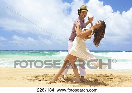 Picture - Portrait of couple dancing on the beach; Kealia, Kauai, Hawaii, United States of America. Fotosearch