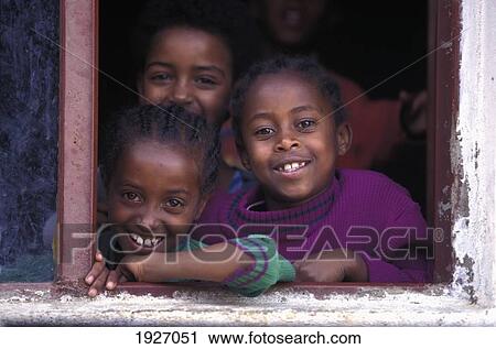 Stock Image - Portrait Of Girls In Window Frame; Addis Ababa, Ethiopia. Fotosearch