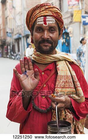 Stock Image - Portrait of Hindu guru asking for tips on the street; Kathmandu, Nepal. Fotosearch