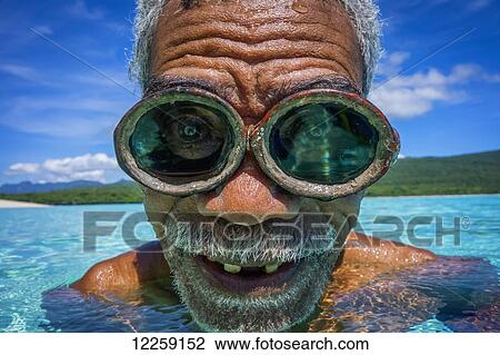 Stock Image - Portrait of local fisherman in the water wearing goggles; Jaco Island, Timor-Leste. Fotosearch