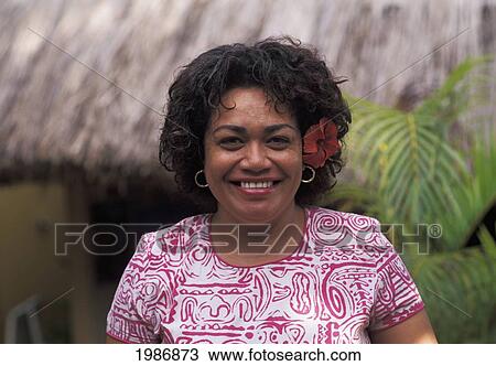 Stock Image - Portrait of mature local woman in colorful dress; Fiji. Fotosearch