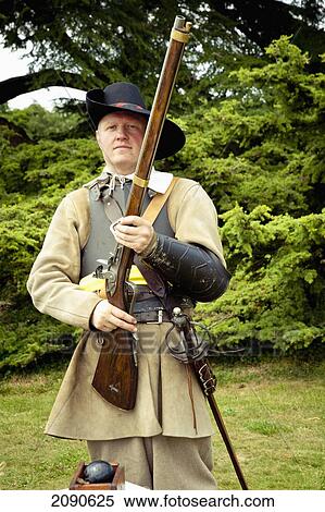 Stock Photography - Portrait Of Mature Man Holding Rifle In Front Of Lacock Abbey, Lacock, Wiltshire, Uk. Fotosearch