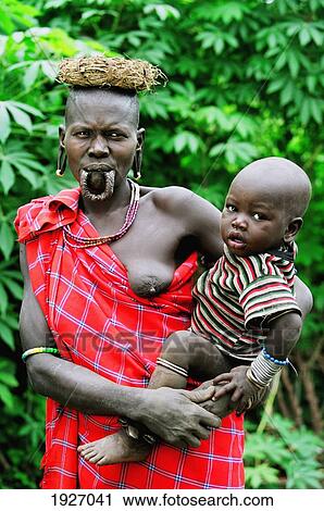 Stock Image - Portrait Of Mursi Tribal Woman With Piercedlower Lip With Son. Fotosearch