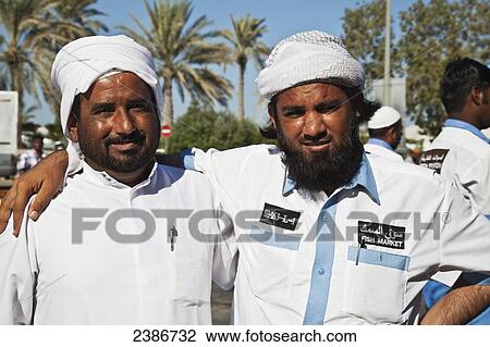 Portrait of two men from the fish market in an embrace; Dubai, United Arab Emirates View Large Photo Image Stock Image - Portrait of two men from the fish market in an embrace; Dubai, United Arab Emirates. Fotosearch