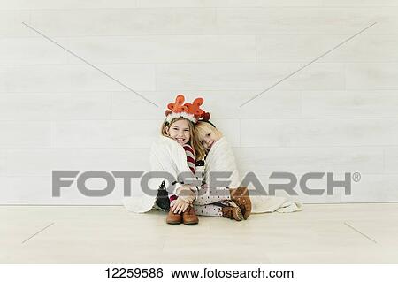 Stock Photograph - Portrait of two young girls against a white wall. Fotosearch