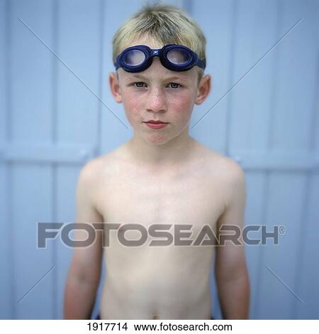 Picture - Portrait Of Young Boy In Swimming Goggles Against Blue Panel. Fotosearch