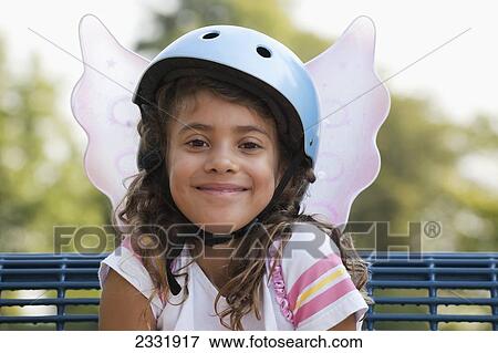 Stock Photo - Portrait Of Young Girl Wearing A Bike Helmet And Fairy Wings; Whitby Ontario Canada. Fotosearch