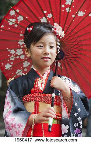 Stock Photo - Portrait Of Young Girl Wearing A Kimono And Holding A Red Paper Umbrella; Tokyo, Japan. Fotosearch