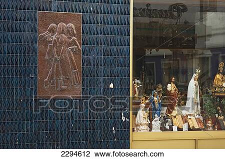 Stock Image - Portugal, Azores, Sao Miguel Island, View of shop with religious items and tile relief; Ponta Delgada. Fotosearch