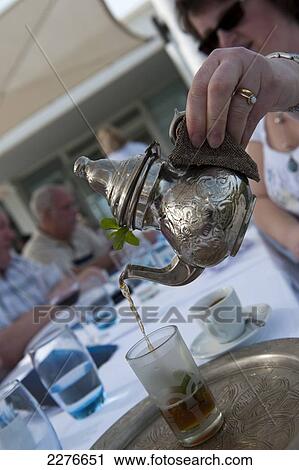 Stock Image - Pouring mint tea, Tunisia's national drink; Djerba, Tunisia. Fotosearch