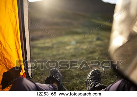 Stock Photography - POV view of hikers feet and the view of tundra from the doorway of a tent, Alaska. Fotosearch