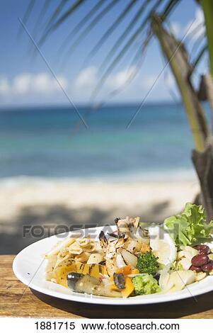 Stock Photography - Prawns And Salad On A Table On The Beach. Fotosearch