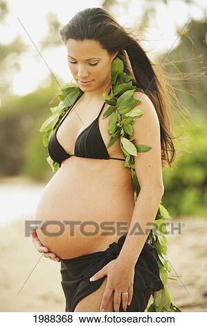 Pregnant Girl Wearing Black Bikini And Green Leaf Lei, Holding Tummy View Large Photo Image Stock Photo - Pregnant Girl Wearing Black Bikini And Green Leaf Lei, Holding Tummy. Fotosearch