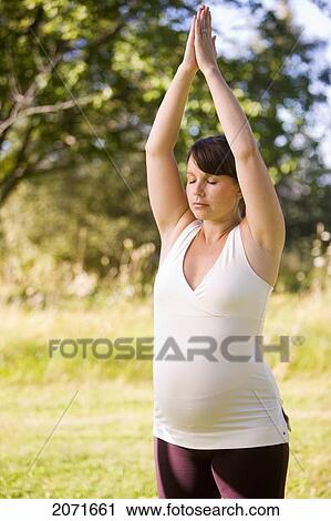 Stock Image - Pregnant Woman Practicing Yoga Outdoors, Mount Albert, Ontario. Fotosearch