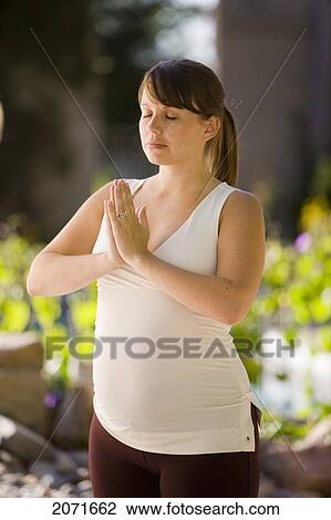 Stock Image - Pregnant Woman Practicing Yoga Outdoors, Mount Albert, Ontario. Fotosearch