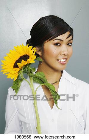 Stock Photo - Pretty Woman Holding A Large Yellow Sunflower.. Fotosearch