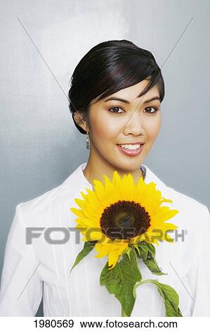 Stock Photo - Pretty Woman Holding A Large Yellow Sunflower.. Fotosearch