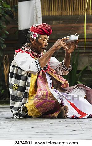 Stock Image - Priest making an offering at a Barong dance performance in Batubulan, Bali, Indonesia. Fotosearch