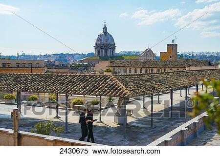 Stock Photography - Priests praying on a rooftop; Rome, Lazio, Italy. Fotosearch