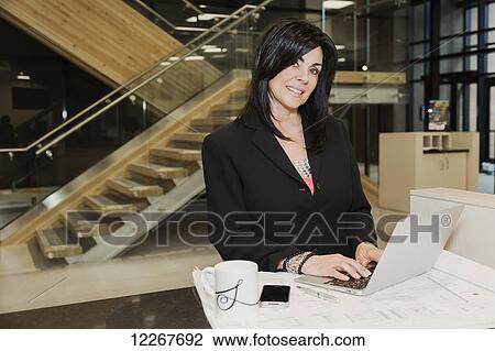 Professional businesswoman using her laptop during office interior construction project; Edmonton, Alberta, Canada View Large Photo Image Stock Image - Professional businesswoman using her laptop during office interior construction project; Edmonton, Alberta, Canada. Fotosearch