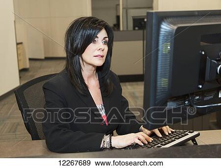 Professional businesswoman working on computer in an open office environment; Edmonton, Alberta, Canada View Large Photo Image Stock Photo - Professional businesswoman working on computer in an open office environment; Edmonton, Alberta, Canada. Fotosearch