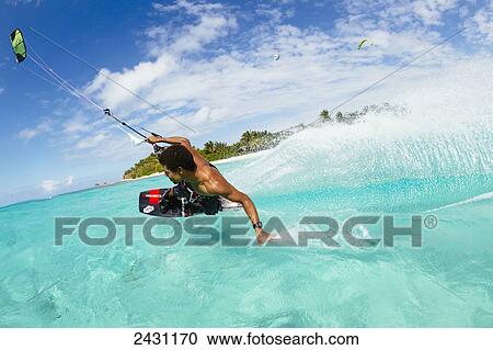 Stock Image - Professional kiteboarder Andre Philip kitesurfing over the crystal blue waters; Necker Island, British Virgin Islands. Fotosearch