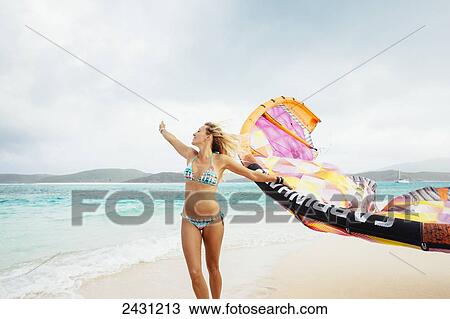 Stock Image - Professional kiteboarder Susi Mai on the beach enjoying the beautiful tropical white sands of the Caribbean; Necker Island, British Virgin Islands. Fotosearch