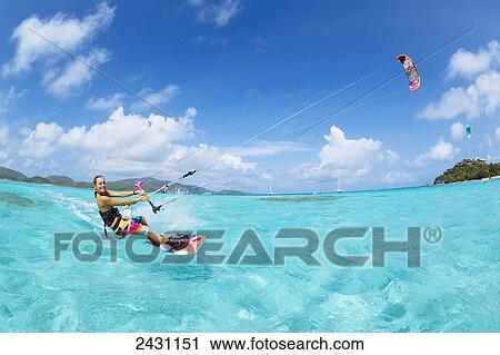 Stock Image - Professional kiteboarder Susi Mai kitesurfing over the crystal blue waters; Necker Island, British Virgin Islands. Fotosearch