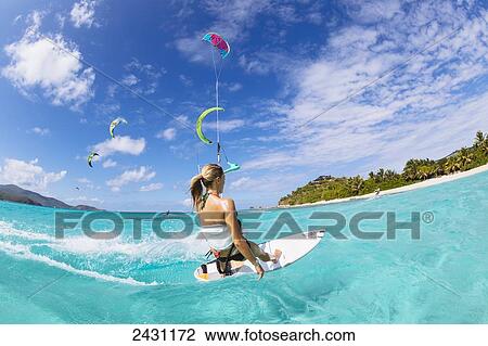 Stock Image - Professional kiteboarder Susi Mai kitesurfing over the crystal blue waters; Necker Island, British Virgin Islands. Fotosearch